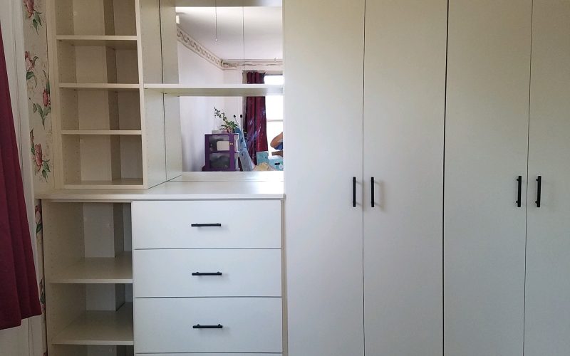 custom white wardrobe with four drawers and two long wardrobe door sections.