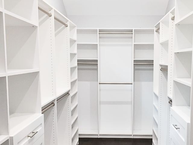 large walk-in closet with white cabinetry