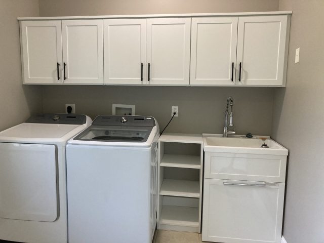 laundry room with white cabinet storage