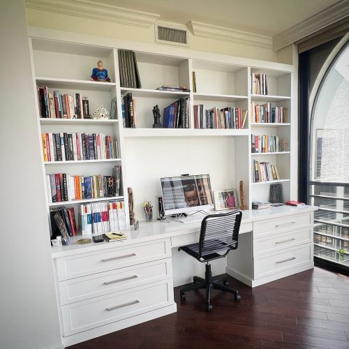 home office with large desk, and shelves with books.